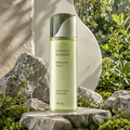 DOZMIOS Balancing Toner displayed on stone among green plants and mossy rocks